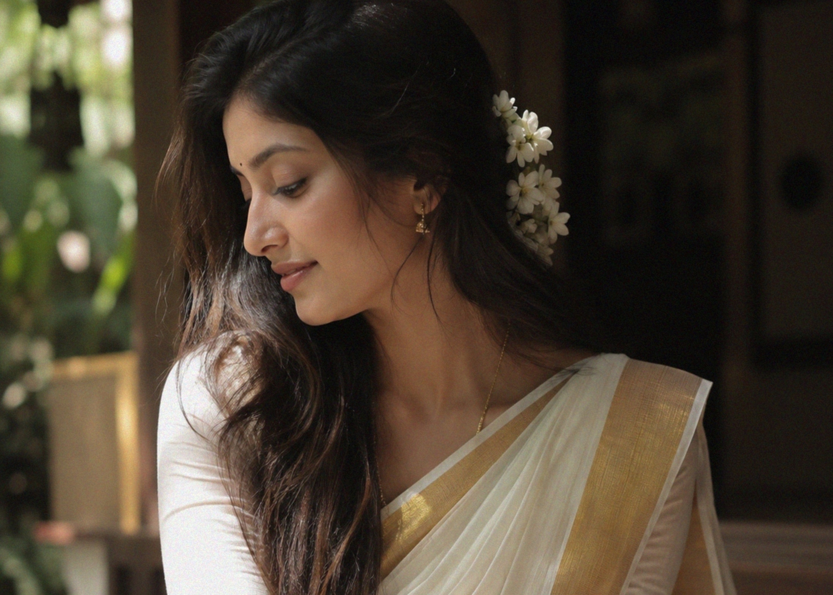 Woman with white gold saree and jasmine flowers for Onam festival in Kerala