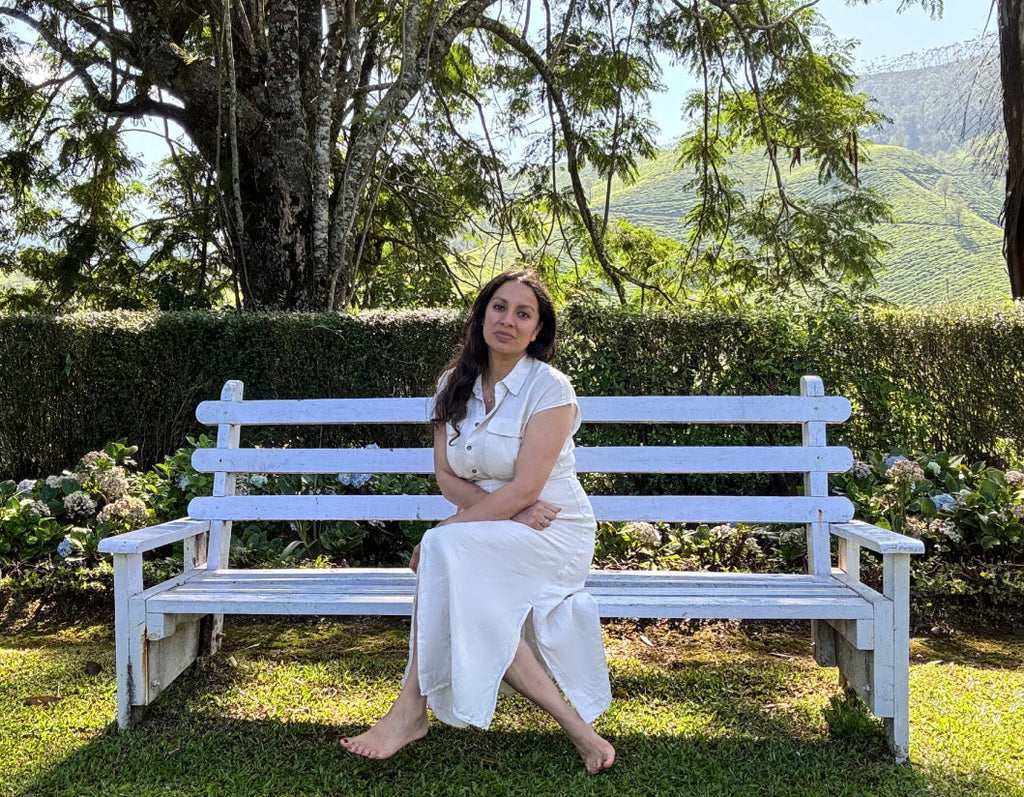 Shadoh Punnapuzha, founder of Taila Skincare sitting on a white bench in Munnar in  Kerala, India.