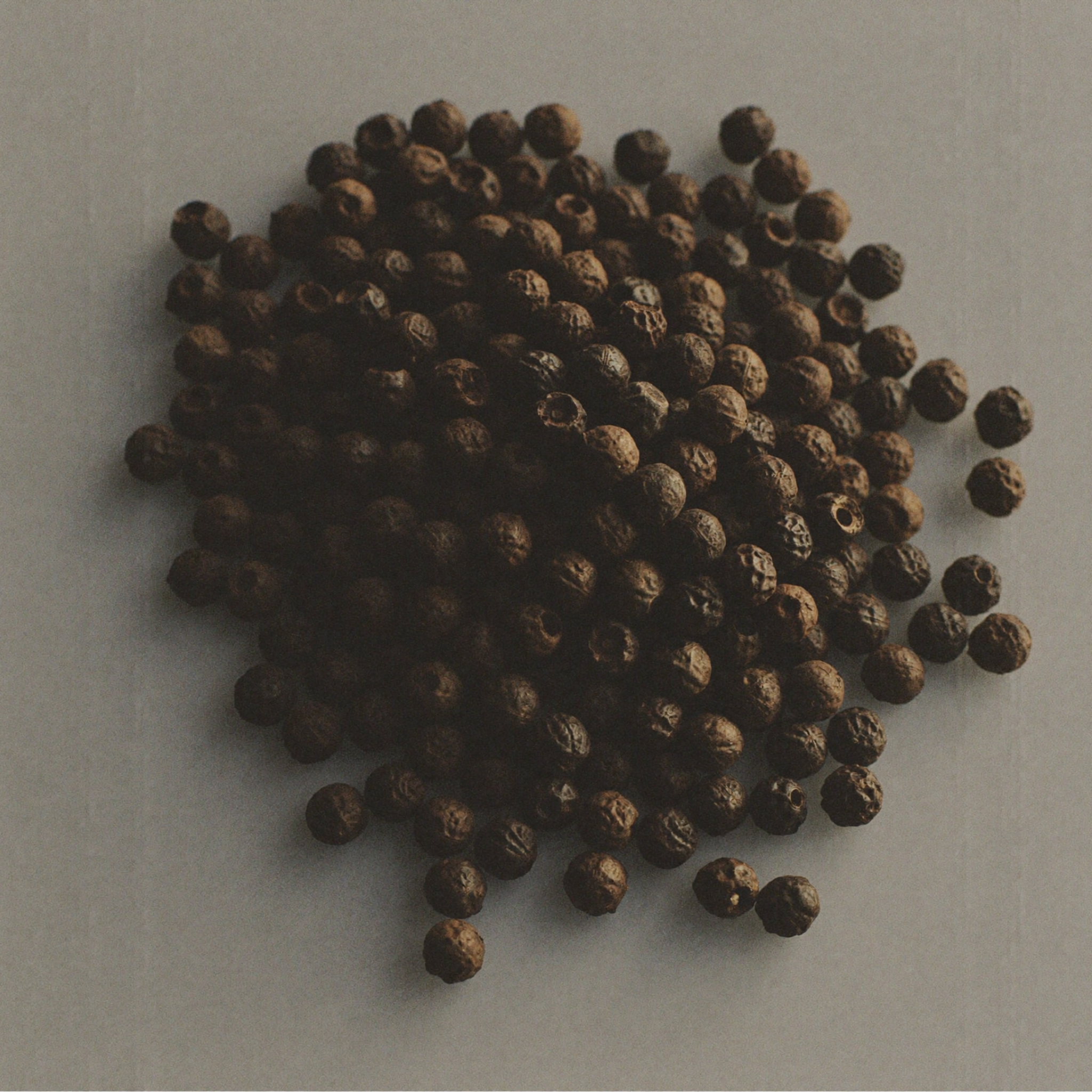 Whole black peppercorns, a stimulating botanical ingredient used in skincare to support circulation and promote smoother-looking skin.