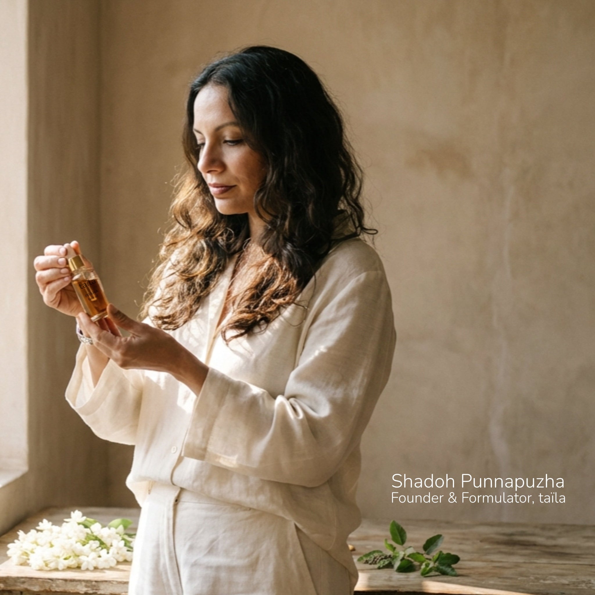 taïla founder and formulator Shadoh working inside her private skincare laboratory, holding a glass dropper filled with a bioactive botanical formula, introducing the root-to-bottle luxury Ayurvedic brand.