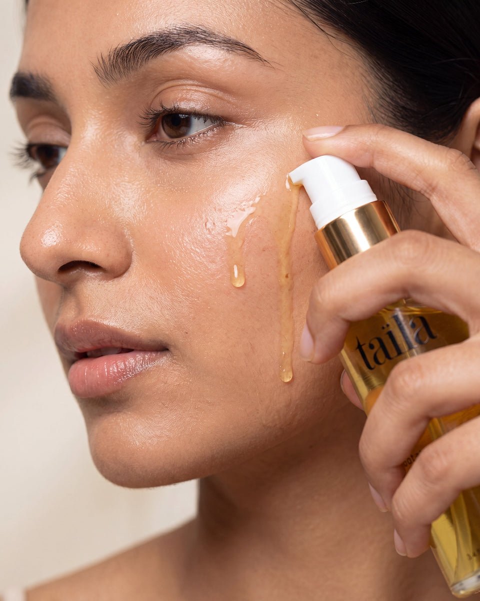 Dispensing golden taila Muhka Botanical Oil Cleanser onto face for a two-step oil cleanse that rinses off easily and deep cleanses pores without stripping skin.
