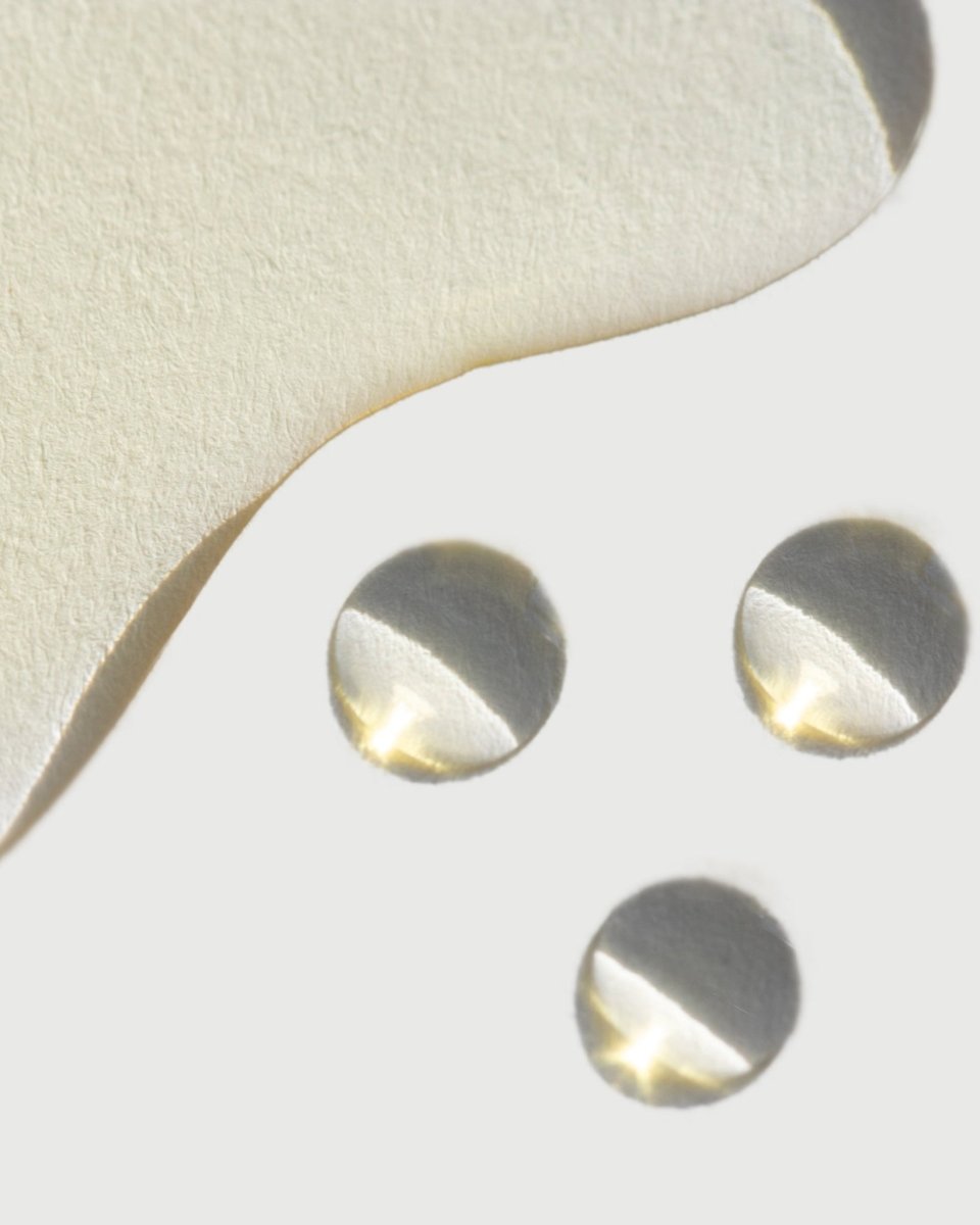 A close-up of the golden, silky liquid texture of taïla PRANA Face Oil on a clean white background.