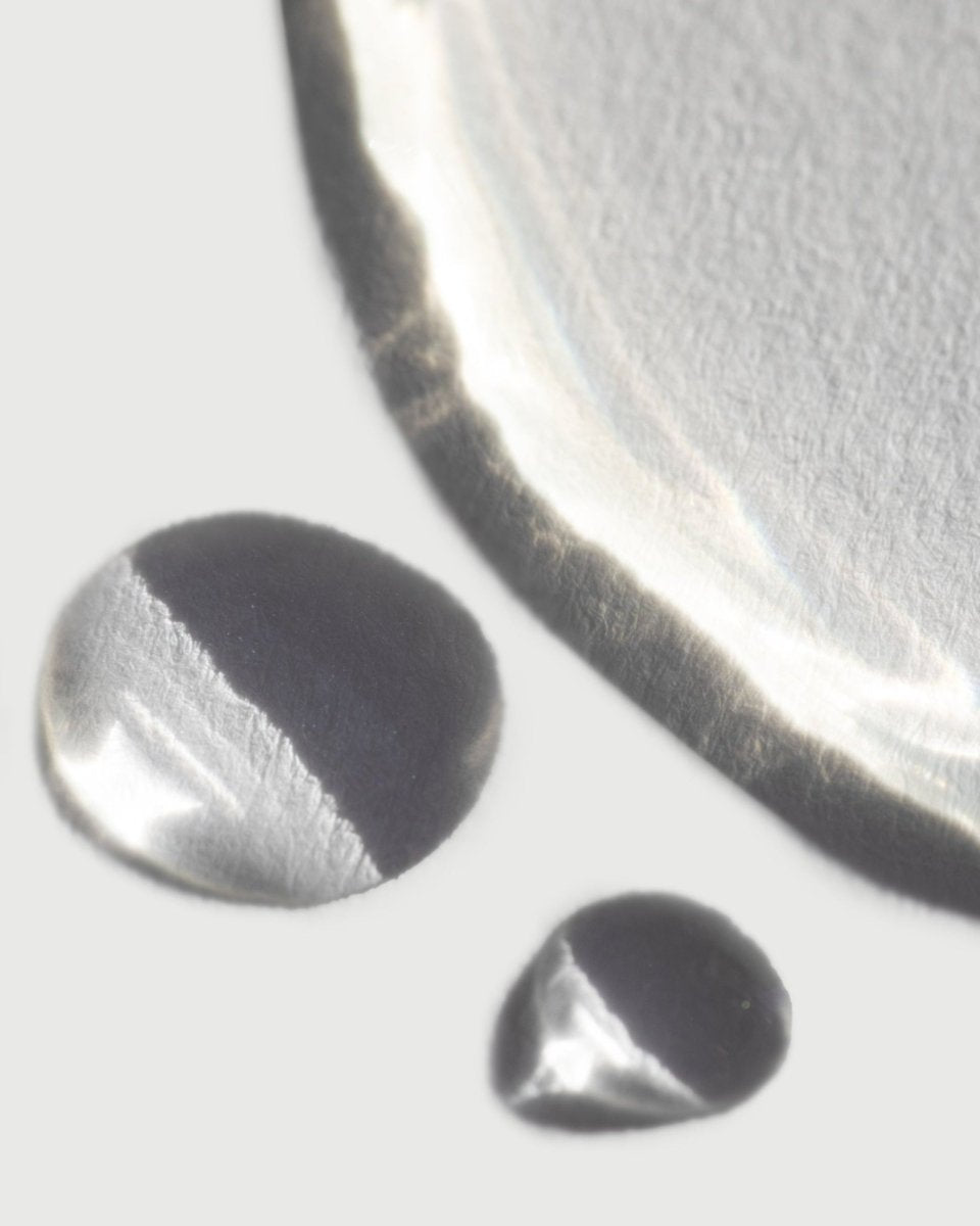 A high-definition macro photograph capturing the crystalline clarity and fine, weightless droplets of VAYU illuminating toning mist, illustrating the pristine fluid balance of our active botanical distillates.